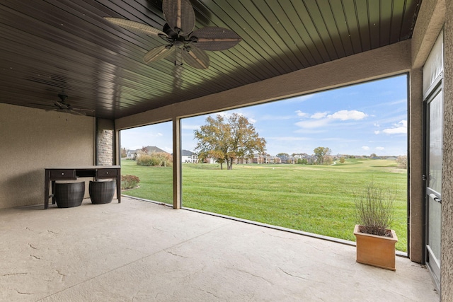 unfurnished sunroom with a ceiling fan