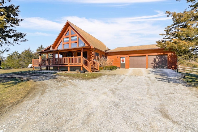 log-style house featuring driveway, an attached garage, log siding, and fence