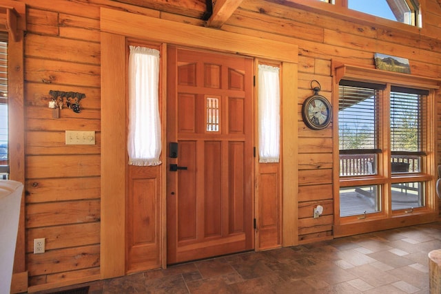 entrance foyer with wooden walls and stone finish floor