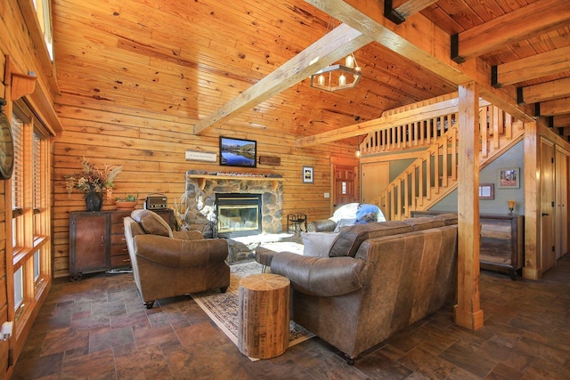 living room with a fireplace, stairway, wood walls, wooden ceiling, and beamed ceiling