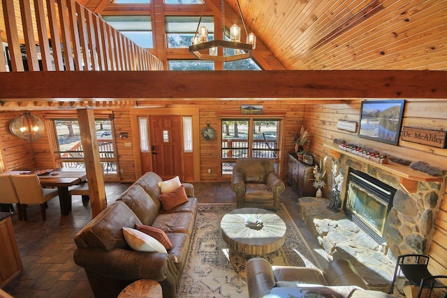 living room featuring high vaulted ceiling, a notable chandelier, wooden walls, a fireplace, and wood ceiling