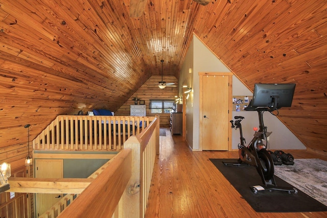 workout room with wood ceiling, wood walls, vaulted ceiling, and hardwood / wood-style flooring