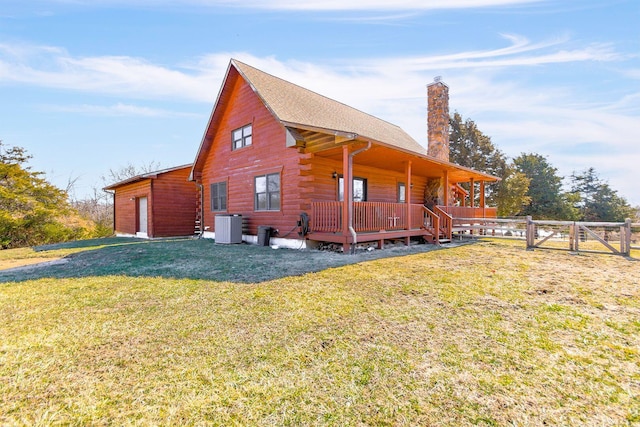 view of side of home featuring a garage, a chimney, fence, a yard, and central air condition unit