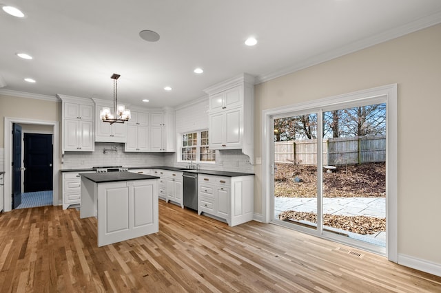 kitchen featuring white cabinets, dishwasher, tasteful backsplash, dark countertops, and crown molding