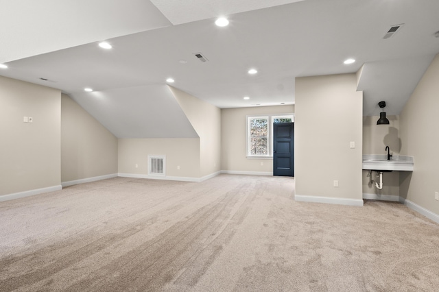 additional living space featuring light colored carpet, visible vents, and recessed lighting