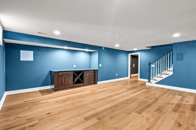 interior space with light wood finished floors, baseboards, stairs, and visible vents