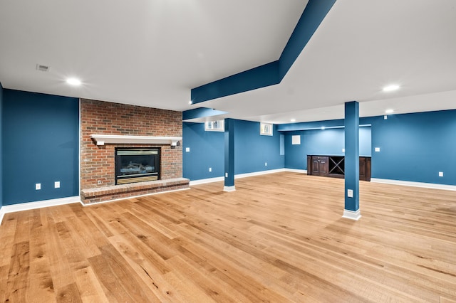 unfurnished living room with recessed lighting, a fireplace, wood finished floors, visible vents, and baseboards