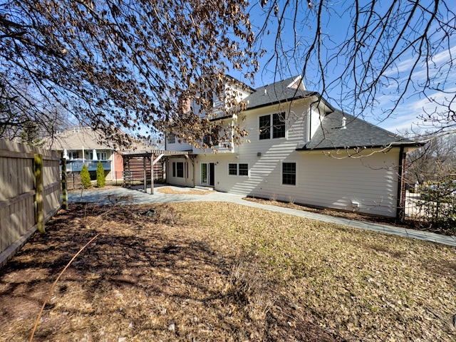 rear view of house featuring a patio, a shingled roof, fence, a deck, and stairs