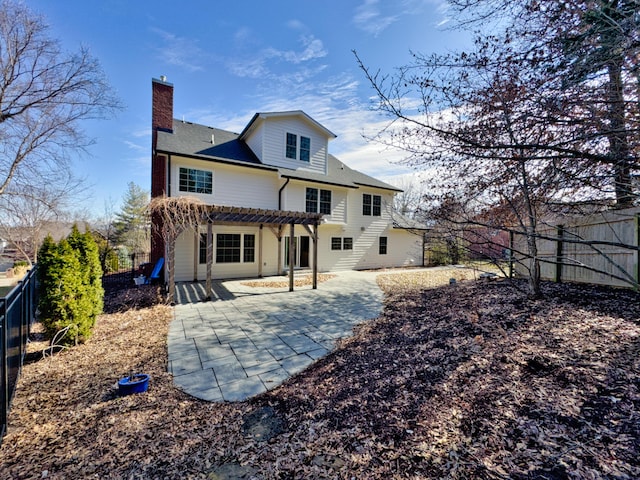 back of house with fence private yard, a chimney, a pergola, and a patio