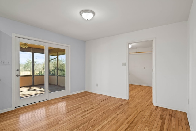 interior space featuring baseboards, light wood finished floors, and access to exterior