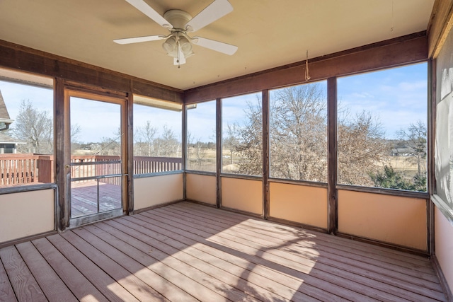 unfurnished sunroom featuring a ceiling fan