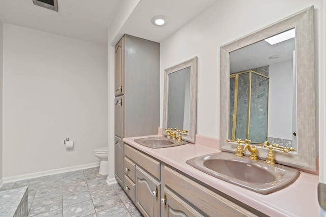 bathroom featuring toilet, double vanity, visible vents, and a sink