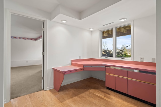 unfurnished office featuring light wood-style flooring, visible vents, and baseboards