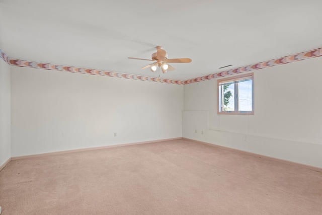 unfurnished room with baseboards, a ceiling fan, and light colored carpet