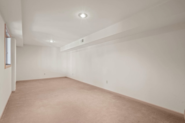 spare room with light colored carpet, visible vents, and baseboards