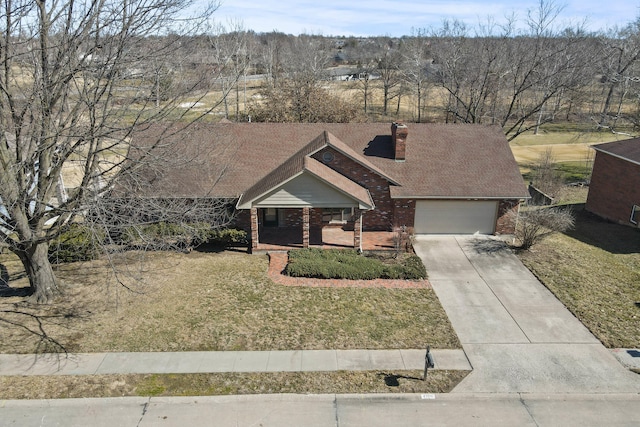 view of front of house with driveway, roof with shingles, a front lawn, and brick siding