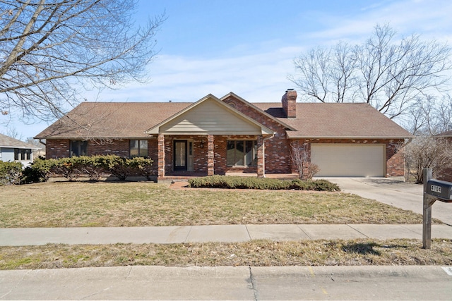 view of front of property featuring an attached garage, a chimney, a front lawn, and brick siding