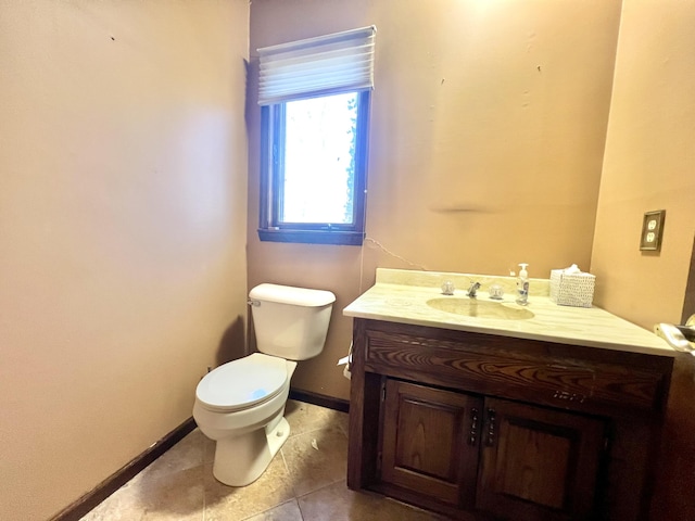 bathroom with tile patterned flooring, baseboards, vanity, and toilet