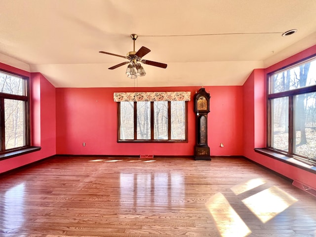 unfurnished room featuring vaulted ceiling, baseboards, and wood finished floors