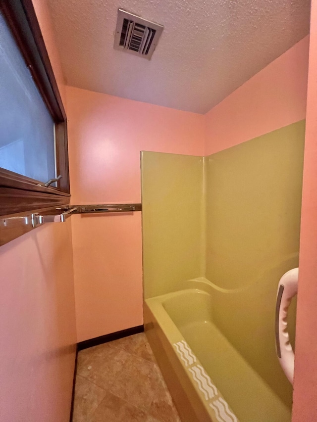 full bath featuring a bath, baseboards, visible vents, and a textured ceiling