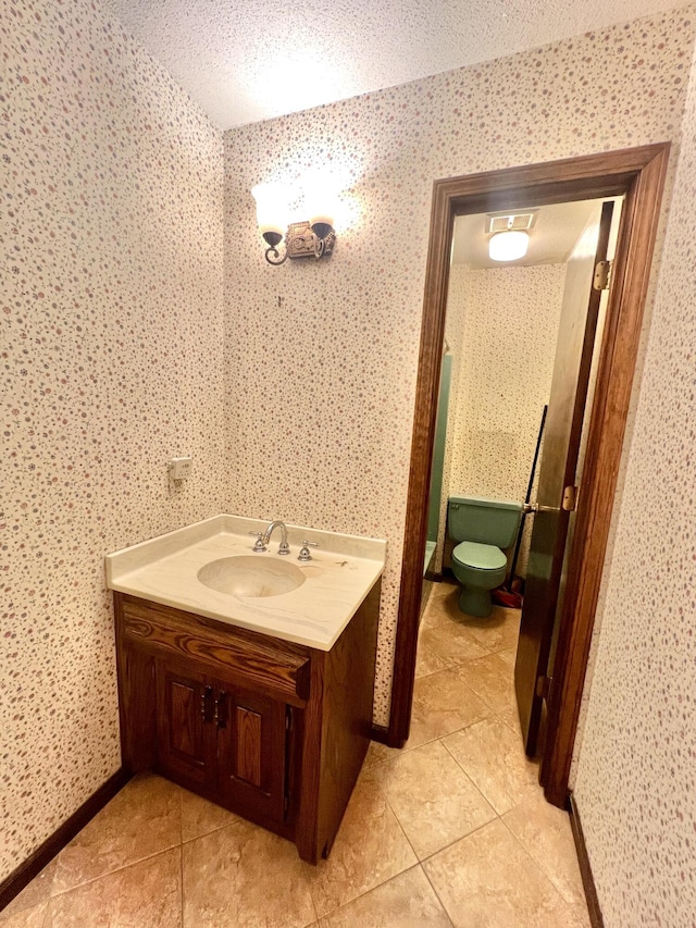 bathroom with tile patterned flooring, vanity, toilet, and wallpapered walls