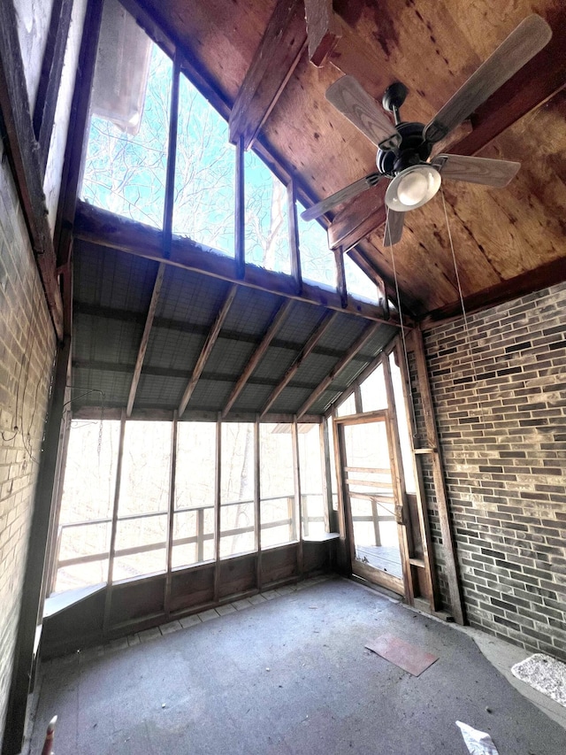 unfurnished sunroom featuring a ceiling fan and vaulted ceiling