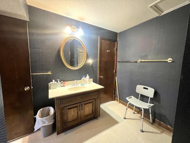 bathroom with baseboards, visible vents, a textured ceiling, and vanity