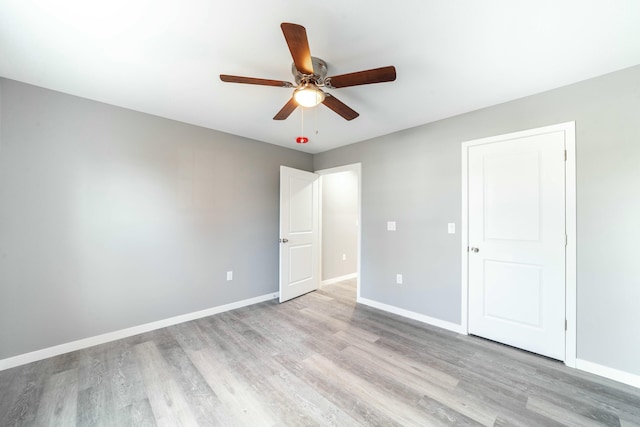 unfurnished bedroom featuring ceiling fan, light wood finished floors, and baseboards