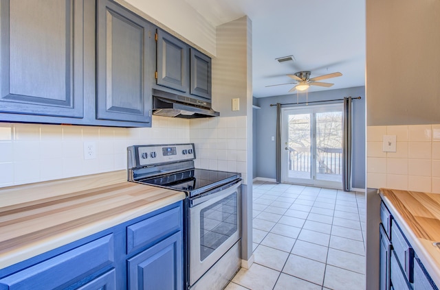 kitchen featuring stainless steel electric range oven, light tile patterned floors, visible vents, butcher block countertops, and under cabinet range hood