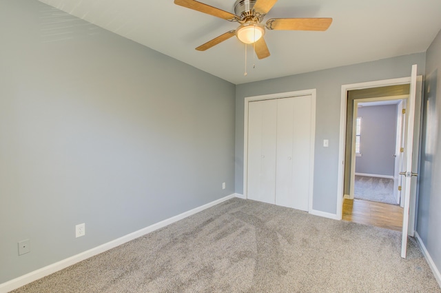 unfurnished bedroom with carpet, a closet, ceiling fan, and baseboards