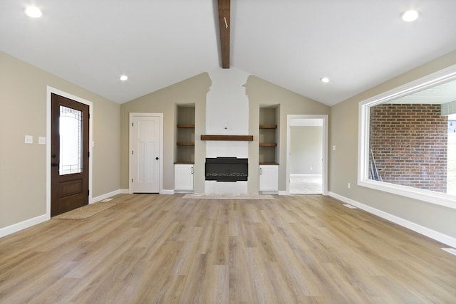 unfurnished living room featuring baseboards, lofted ceiling with beams, built in shelves, light wood-style floors, and a fireplace