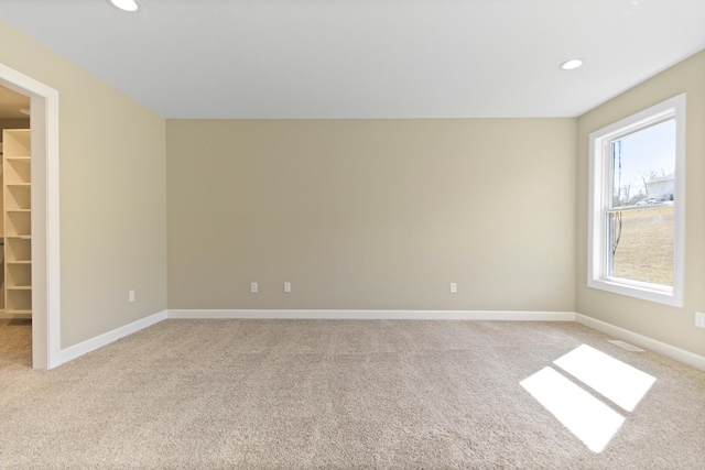 unfurnished room with recessed lighting, baseboards, and light colored carpet