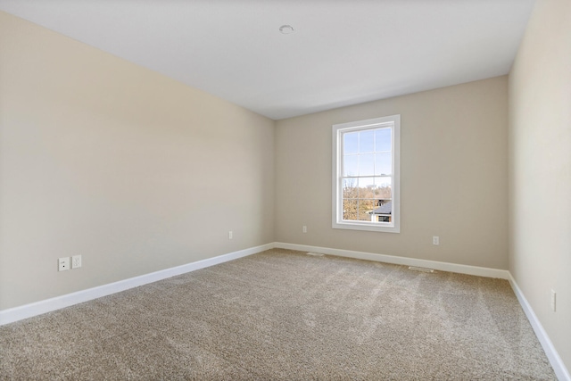 carpeted empty room with baseboards