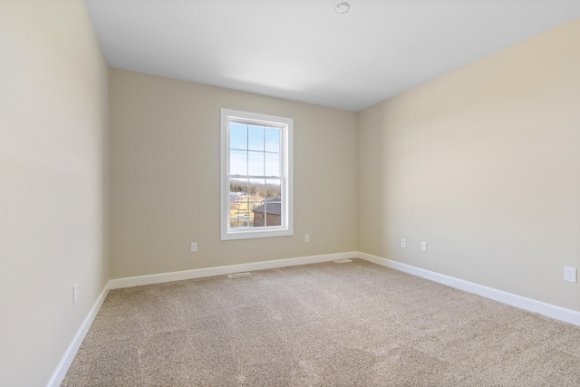 carpeted spare room featuring baseboards