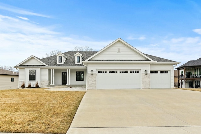 view of front of property featuring a garage, a shingled roof, a front lawn, and concrete driveway