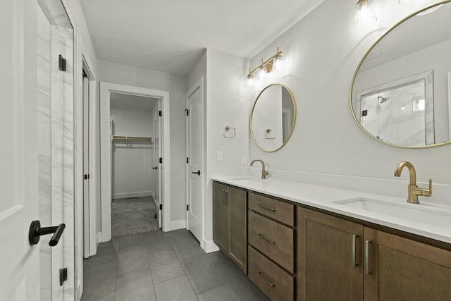 full bath with a walk in closet, tile patterned flooring, a sink, and double vanity