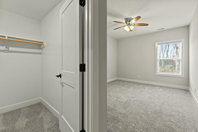 walk in closet featuring ceiling fan, carpet flooring, and visible vents