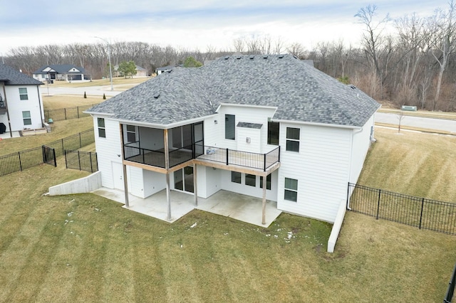 rear view of property with a patio area, roof with shingles, a fenced backyard, and a yard