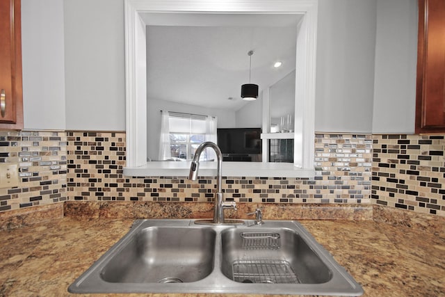 kitchen with lofted ceiling, tasteful backsplash, and a sink