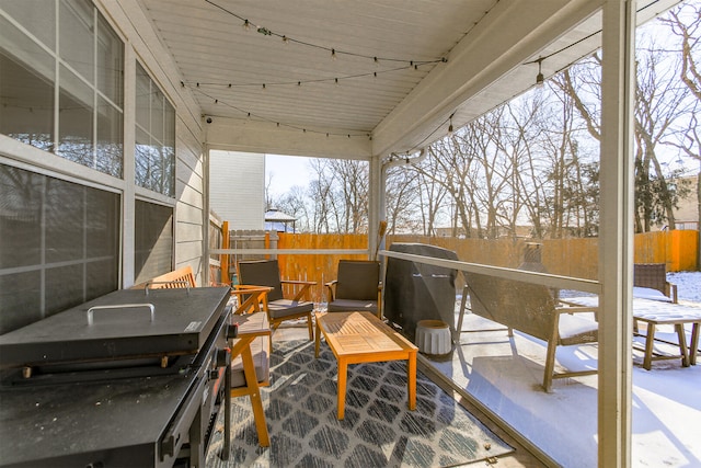 snow covered deck featuring a patio area and fence