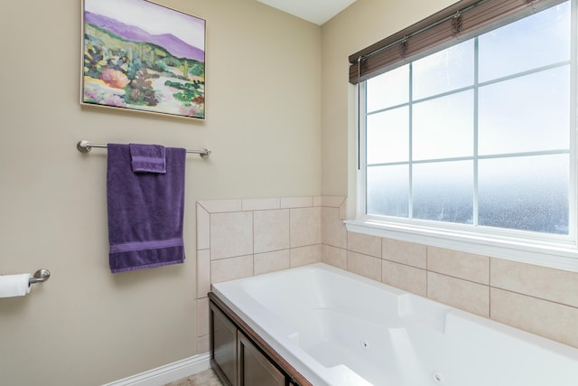 full bathroom featuring a jetted tub and baseboards