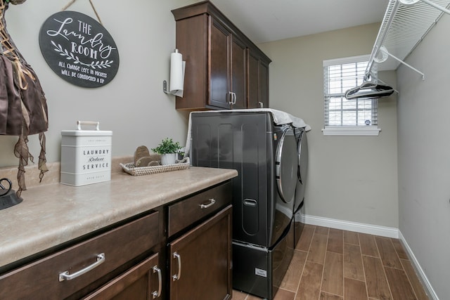 laundry area featuring baseboards, separate washer and dryer, cabinet space, and wood tiled floor