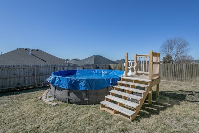 view of swimming pool featuring a fenced in pool, a fenced backyard, and a yard