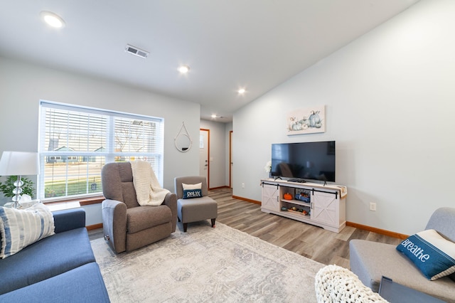 living room with recessed lighting, visible vents, vaulted ceiling, wood finished floors, and baseboards