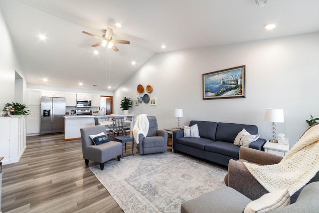 living area featuring a ceiling fan, vaulted ceiling, wood finished floors, and recessed lighting