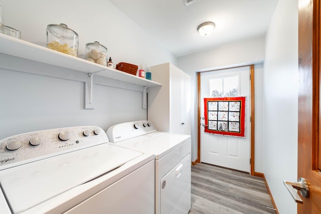 laundry area featuring laundry area, light wood finished floors, washing machine and dryer, and baseboards