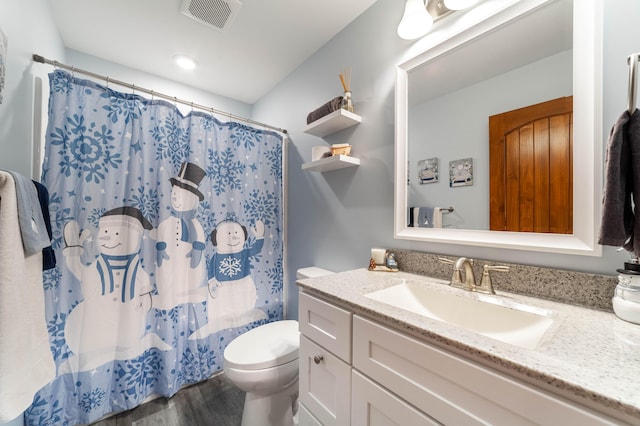 bathroom featuring visible vents, toilet, wood finished floors, curtained shower, and vanity