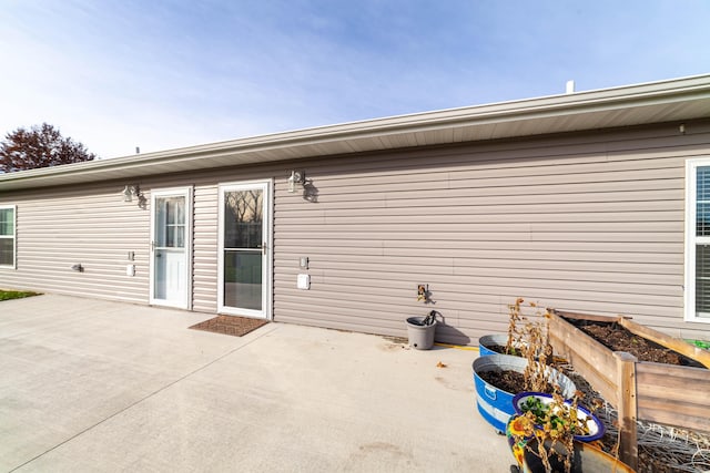 back of house featuring a patio area and a garden