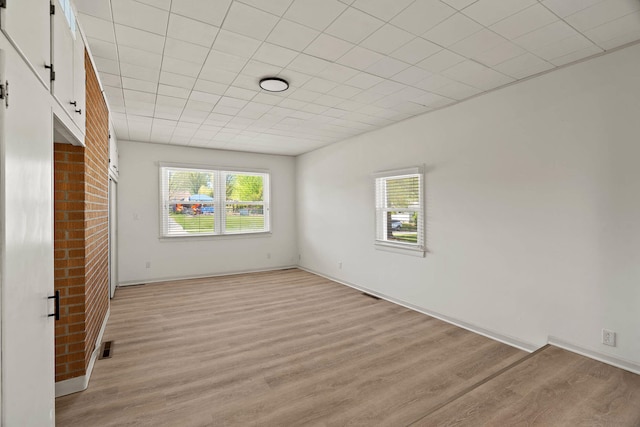 empty room featuring light wood-type flooring and visible vents