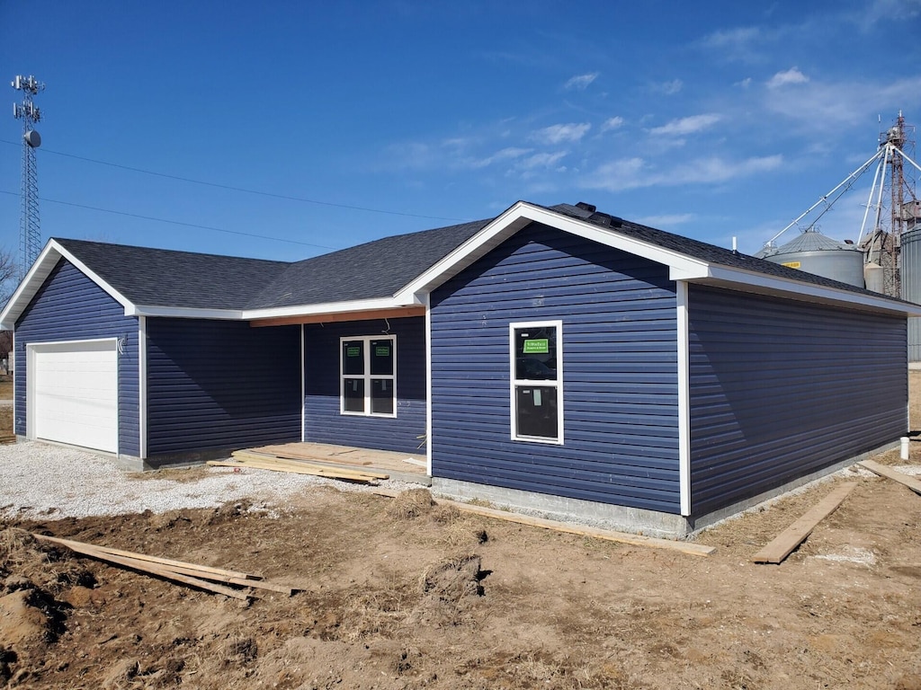 view of front of property featuring a shingled roof and an attached garage